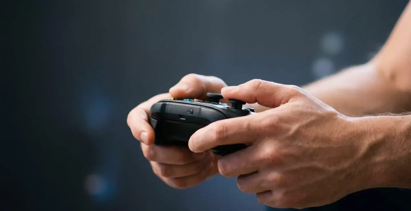 Close-up of hands gripping a game controller with dramatic lighting highlighting tactile engagement and finger positioning during gameplay
