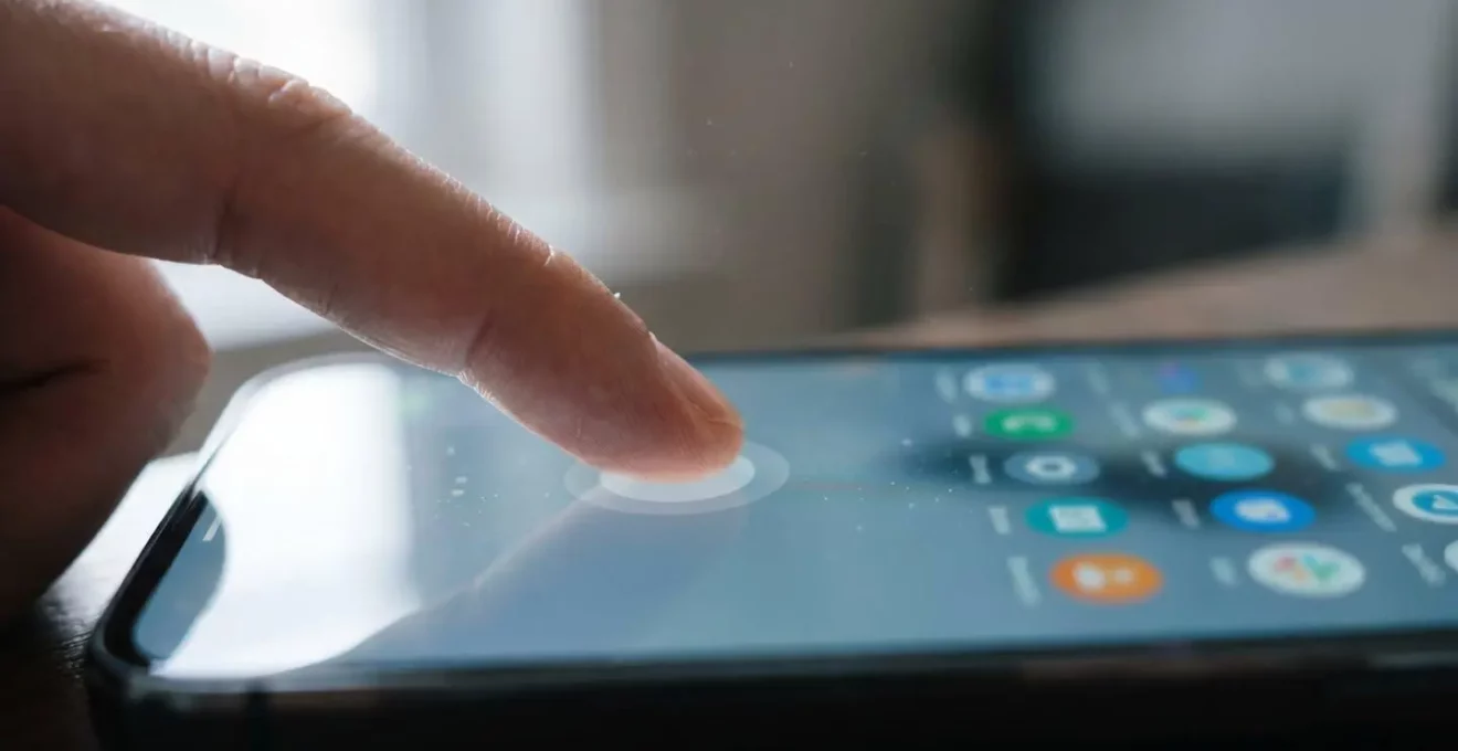 Close-up of fingers performing long-press gesture on smartphone screen revealing contextual menu